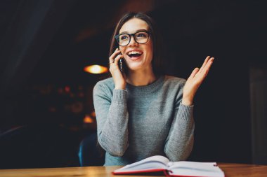 Arkadaş arama ve eğitim ve eğitim kitabı ile üniversite Semineri için hazırlanıyor süre iyi haber söylüyorum optik gözlükler mutlu öğrenci. Duygusal olumlu genç kadın cep üzerinde söz