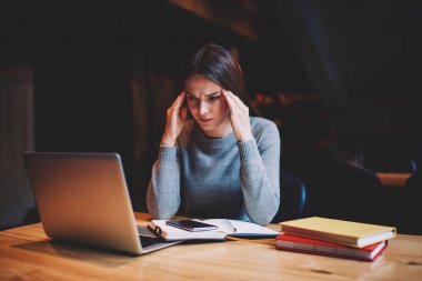 Yorgun yetenekli öğrenci izlerken sıkıcı webinar ve dizüstü bilgisayar cihaza kablosuz 4 g ile tahta masada oturan internet alan coworking kitaplar bağlı eğitim semineri için hazırlanıyor