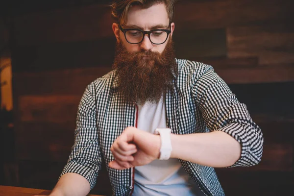 Skäggiga Hipster Guy Optiska Glasögon Tittar Visning Moderna Smartwatch Och — Stockfoto