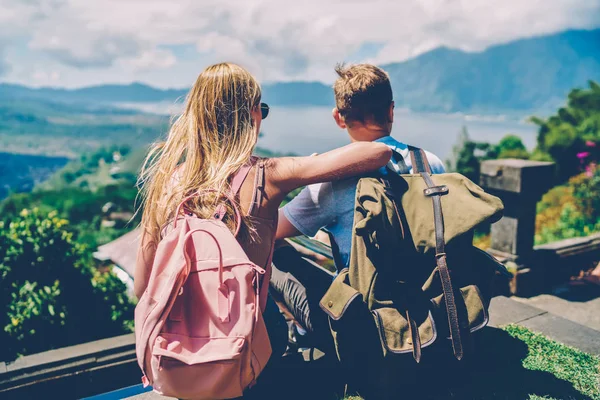 男性和女性旅行者的背部视图与背包探索热带岛屿一起喜欢活跃的雷斯顿周末 情侣爱上背囊看美丽的自然坐在山上 — 图库照片