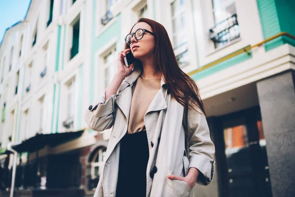 魅力的な自信を持っている女性は電話のアプリケーションを使用してモバイルで会話を持つカジュアルな服に身を包んだ かなり内気な少女が歩きながら現代のガジェットを介して友人とのコミュニケーション — ストック写真