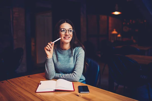 Mujer Joven Bonita Gafas Ópticas Sentada Mesa Madera Con Cuaderno —  Fotos de Stock