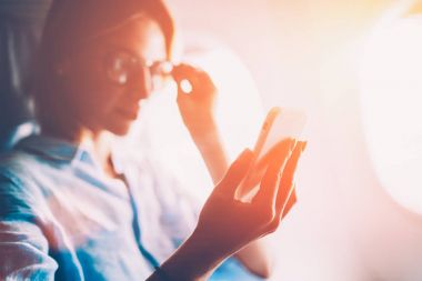 Çekici kadın telefon uçak kabin internete bağlanmak için ağ haber tarama mobil, genç kadın Gezgin ağlarda haber okuma üzerinde uçuş sırasında vakit uçakla seyahat