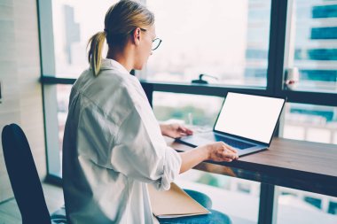 Gözlük tarassut video üstünde modern bilgisayar boş ekran alanı için reklam ile internet sitelerinde becerilerini geliştirmek için yeni grafik fikirlerle yaratıcı kadın web tasarımcısının arkadan görünüm