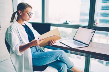 Muhasebe raporları klasöründe boş ekran alanı ile dizüstü bilgisayar aygıt kapalı ofis iç oturan işinizi web sitesi için verimli çalışması sırasında kontrol dalgın kadın Ofis Müdürü