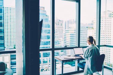 Arkadan Görünüm şık ofis Studio cityscape ile verimli çalışması için yüksek hızlı internet bağlantısı kullanarak modern ağ dizüstü bilgisayarı, yaratıcı profesyonel tasarımcı çalışma. Boş ekran alanı web sayfası için