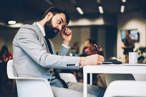 Seitenansicht Des Nachdenklichen Bärtigen Firmeninhabers Der Darüber Nachdenkt Arbeitszeitpläne Notizblock — Stockfoto