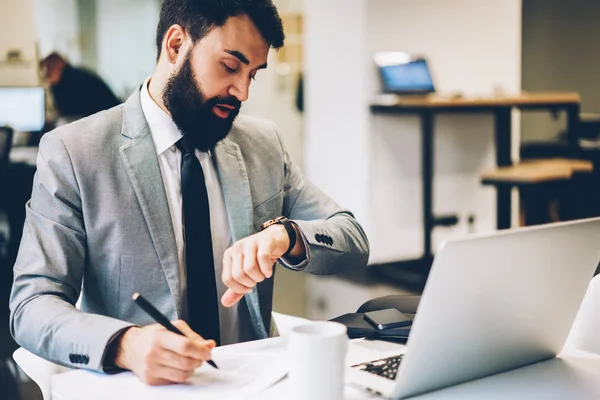 Knappe Mannelijke Advocaat Horloge Kijken Terwijl Het Opschrijven Van Informatie — Stockfoto