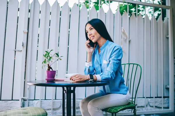 年轻华丽的积极黑发女商人在户外活动时通过蜂窝手机与伴侣进行移动对话 逗人喜爱的微笑的女性人在电话反对墙壁与拷贝空间 — 图库照片