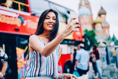 Asyalı kız alma selfie pay gezi otobüs gezisinde sahip ağlar için gülümseyen neşeli kadın seyahat sırasında şehir tur ayakta Çift katlı, yakınındaki smartphone kamerada fotoğraf yapma