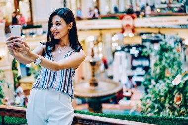Modaya uygun kıyafet selfie serbest zaman sırasında alışveriş merkezi, mutlu Asyalı kız için reklam kopya alanı yakınındaki fotoğraf ayakta yapmak için poz yapmak için smartphone uygulama kullanarak neşeli genç kadın