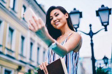 Selfie şehir üzerinde geziniyor smartphone kamera sokak yapım gülümseyen Asyalı kız, şehir turu yapmak fotoğraf pay yolu ile hareket eden sosyal ağlar için ve 4 g bağlantı sırasında yeniden neşeli genç kadın