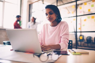 Proje için serbest arama bilgilerini laptop, esmer öğrenci çalışma alanı oturan e-öğrenme artan bilgi zaman harcama üzerinde çalışan dalgın afro Amerikan kadın web tasarımcı
