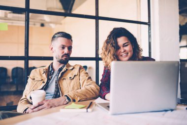 Genç yetenekli kız öğrenci dizüstü bilgisayar resmi olmayan toplantı sırasında tartışma sırasında office coworking ara online video izlerken sahip meslektaşları kullanarak projesi koçluk yapmak sunma