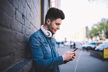 Pay fotoğraf ağlar üzerinden mobil zevk serbest zaman, genç caddenin üzerinde duran yakışıklı hipster adam adam hesabına bankacılık hizmet uygulama smartphone kullanarak kontrol para
