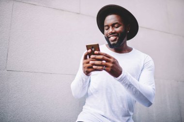 Neşeli afro Amerikan adam şık aşınmaya sosyal ağlar mobil zevk esmer serbest zaman açık havada, mutlu adam izlerken komik video tanıtım alanının yakınında smartphone cep telefonu ile fotoğraf görüntüleme