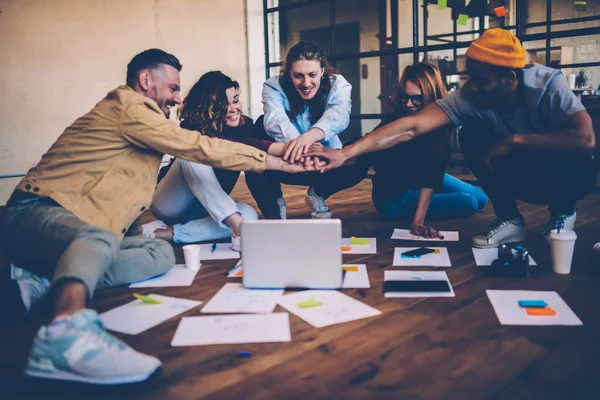 Group of young employees using teambuilding concept feeling unity for reaching success, happy male and female team members celebrating achievement making startup together using laptop computer