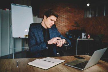 Kol saati bildirim getting yeni haber mahsuldar iş düzenlemek için modern araçlar kullanarak dolap, zengin iş adamı oturan dokunmatik ekran üzerinde kontrol deneyimli Mali İşler Müdürü