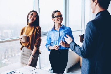 Erkek patron üretken işlemle memnun ile görüşme sırasında dostça konuşma işbirlikçi çalışma işlemi sırasında kahve molası sırasında olumlu iş arkadaşları gülümseyerek neşeli kadın çalışanların