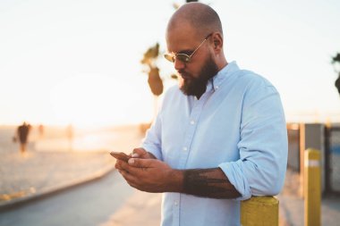 Şık kıyafeti posta smartphone app doğrulayan üzerinde kontrol yakışıklı adam açık havada, web sayfası ayakta rezervasyon hipster adam bloglama sosyal ağlar paylaşım dosyaları modern cep telefonu üzerinden sakallı