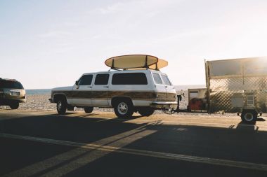 Ekipman için dalga köpüğü-okyanus sahil yolu üzerinde güneşli gün boyunca sürüş ile otomobil, üstte longboards ile hafta sonları aktif spor hobi summe harcama için deniz kıyı yakınındaki park etmiş kamyon