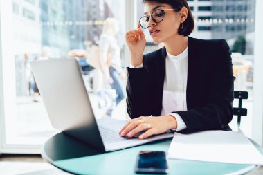 Web tarama ve kafede oturan proje hakkında geribildirim için bekleyen profesyonel kadın Yöneticisi yoğunlaşmıştır. Kendine güvenen avukat netbook uzaktan çalışma bağlı 4 g kablosuz internet