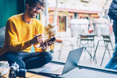 Neşeli öğrenci notları Not Defteri'nde dizüstü bilgisayar online komik webinar sırasında yapma gözlük. Yabancı kelime öğrenme ile video izlerken bilgileri yazma gözlük olumlu adam