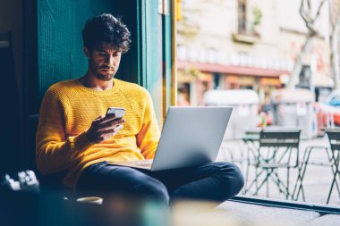 Sakallı grafik tasarımcı smartphone cep telefonu ile gelen bildirim okuma bağlı 4 g için süre çalışma serbest bilgisayar, internet. Netbook eğitim sırasında cep mesajı kontrol hipster adam