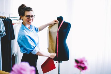 Ünlü tasarımcı popüler şık showroom atelier çalışan dikiş yeni koleksiyonu için siyah manniquin tedbirlerinin yapma gözlük neşeli profesyonel terzi portresi yarım uzunluk
