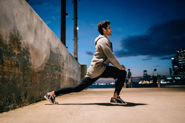 Professional Passar Mannen Göra Stretchingövningar Benen Sport Träning Kväll Sidovy — Stockfoto