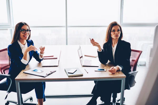 自信的女性财务经理在典雅的正式穿戴创造解决方案一起 经验丰富的女企业家计划公司预算坐在会议桌上的工作过程 — 图库照片
