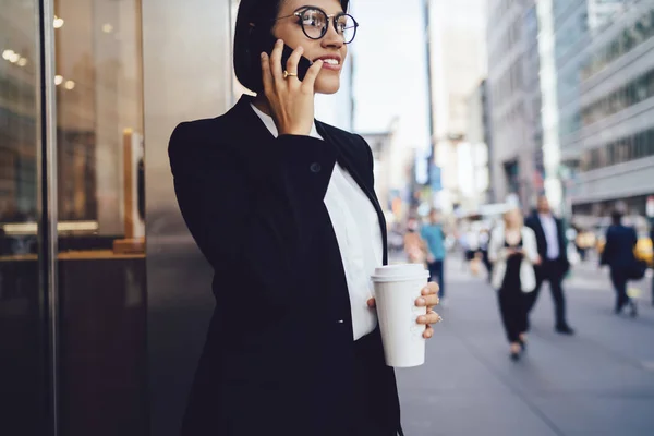 近代的な都市の大都市でおいしいコーヒーを飲みながら散歩着信呼び出しに答える眼鏡で豊かなのプロの弁護士のイメージをトリミングします 携帯で話している陽気な女性銀行員 — ストック写真