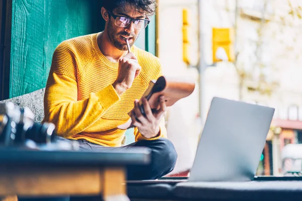 Koncentrált Fiatalember Szemüvegek Gondolkodás Írásban Esszé Jegyzettömb Modern Laptop Számítógép — Stock Fotó