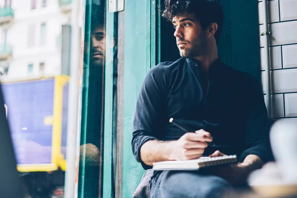 Toughtful Hipster Guy Dressed Black Shirt Looking Out Window Writing — Stock Photo, Image