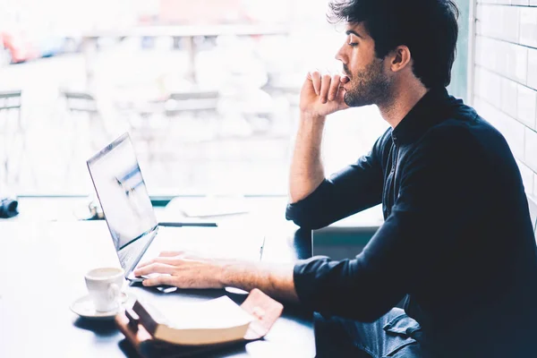 Diseñador Gráfico Masculino Pensativo Viendo Webinar Dispositivo Portátil Moderno Sentado — Foto de Stock