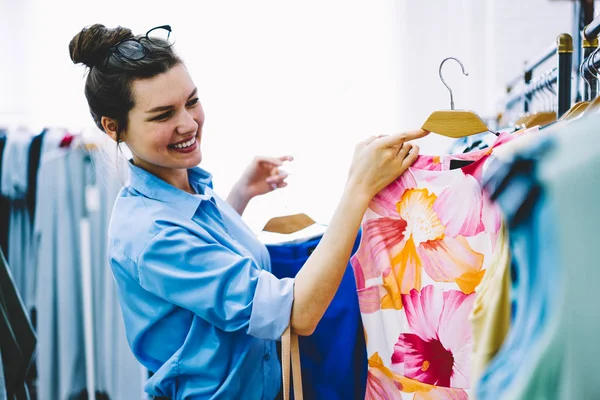 快乐的女设计师选择礼服为自己的新收藏站在陈列室与彩色服装在手 时装设计师与时尚纺织生产发展商务 — 图库照片