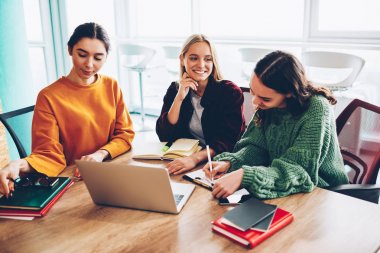 Yeni çalışma programı oluşturma ve şık ofis modern dizüstü aygıtı ile tablo toplantı oturan brifing sırasında tasarım şirketi geliştirilmesi üzerinde ortak çalışma başarılı genç kadın girişimciler