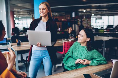 Neşeli genç kadınlar birbirleriyle kendi moda iş ofis iç çalışma geliştirmek için başarılı fikirler hakkında iletişim kurmak. Pozitif öğrenciler tasarım proje oluşturma sırasında gülüyor