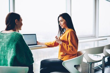 İki neşeli öğrenci modern dizüstü oturan mola sırasında birbirleriyle iletişim kurmak için 4 g bağlı internet. Boş ekran netbook çalışan tasarım projesi tartışmaya olumlu genç kadın