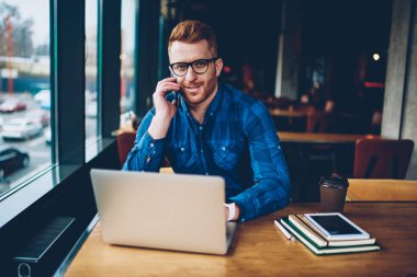 Şık kafe iç Ücretsiz 4 g kullanarak dizüstü bilgisayar aygıt Web sitelerinde bilgi e-öğrenme sırasında ararken Smartphone'da arkadaşıyla konuşurken gözlük başarılı öğrenci portresi