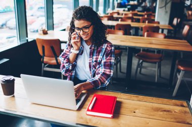 Sartphone ahşap masaüstü ile ders kitapları, üniversitede okuyan ise 4 g kablosuz internet bağlantısı ile modern netbook üzerinde e-posta kontrol ederken konuşmak çok gülümseyen Afro-Amerikan öğrenci