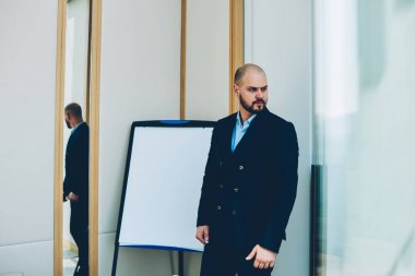 Akıllı erkek tüccar siyah apparer ayakta kurulu sahte finansal haber iş sunum için alanı ile yakınındaki giymiş. Profesyonel Koç resmi aşınmaya eğitim semineri için hazırlanıyor