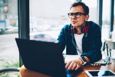 Genç yakışıklı yetenekli erkek blogger hakkında yeni makale yayın kişisel web sayfası üzerinde durulması şık kıyafeti giymiş. İyi görünümlü akıllı freelancer özellikleri için müşteri projenin uygulanması