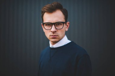Kendine güvenen zeki erkek kişinin yarım uzunluk portre kentsel ayarı boş zaman zaman harcama şık elbise giymiş. Trendy gözlük kamera açık havada duran süre seyir serin hipster adam