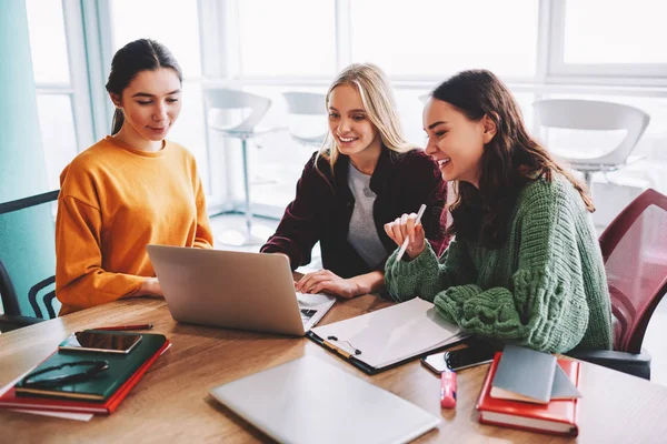 Üretken webinar birlikte laptop oturma çalışma işlemi sırasında izlerken pozitif kadın tasarımcılar bağlı kablosuz 4 g için Internet. Kendi office projesinde birlikte çalışma başarılı genç kadın