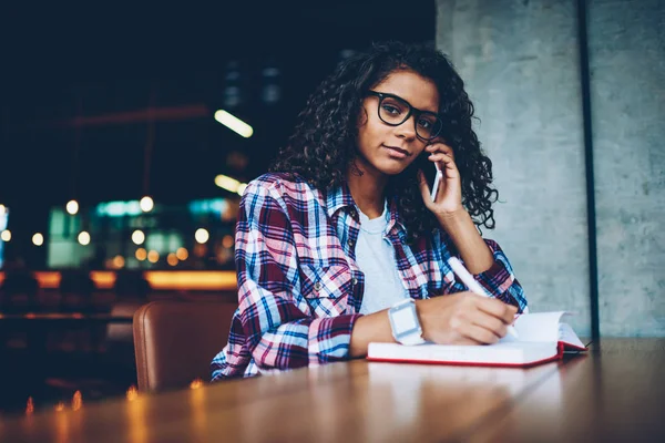 Not defteri metin bilgileri yazarken işleci ile n smartphone söz kıvırcık saçlı sevimli koyu tenli öğrenci portresi. Afro Amerikan hippi kız cep üzerinde iletişim