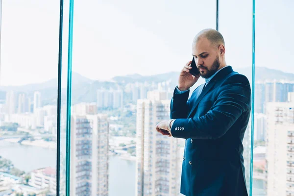 Pensativo Abogado Masculino Mirando Reloj Pulsera Mientras Habla Teléfono Inteligente — Foto de Stock