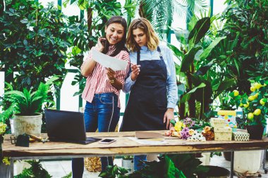 Rapor, sera sahibi ile orangery ayakta vasıl okul sırası iş planlaması hakkında konuşurken pazarlamacı kontrol çiçek perakende mağaza satış geliri ile başarılı kadın meslektaşları memnun