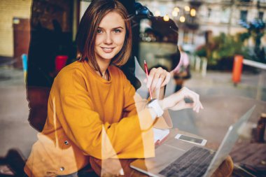 Dijital kol saati ise kameraya bakıyor ve gülümsüyor zaman izleme çekici genç kadın yarım uzunluk portre. Büyüleyici işkadını modern elektronik smartwatch denetimi zamanında