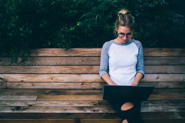 Hippi kız açık havada şehirdeki, genç erkek sohbet ve sosyal ağlar CIT bankta oturmuş gönderme için netbook kullanarak dizüstü bilgisayar ve Internet bağlantısı kullanarak uzak iş zevk